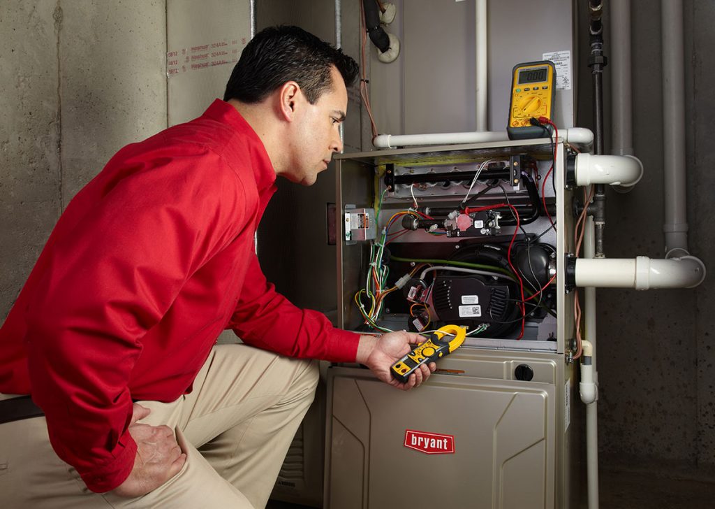 HVAC technician repairing an indoor furnace in Sandy