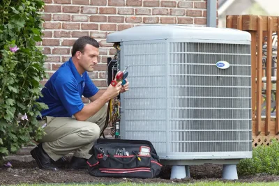 design-air-heating-and-air-conditioning-decatur-il-05 – Copy HVAC technician inspecting an outdoor air conditioning unit in Sandy, UT