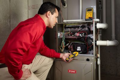 furnace repair Heating and air conditioning technician servicing an indoor furnace in Sandy, UT